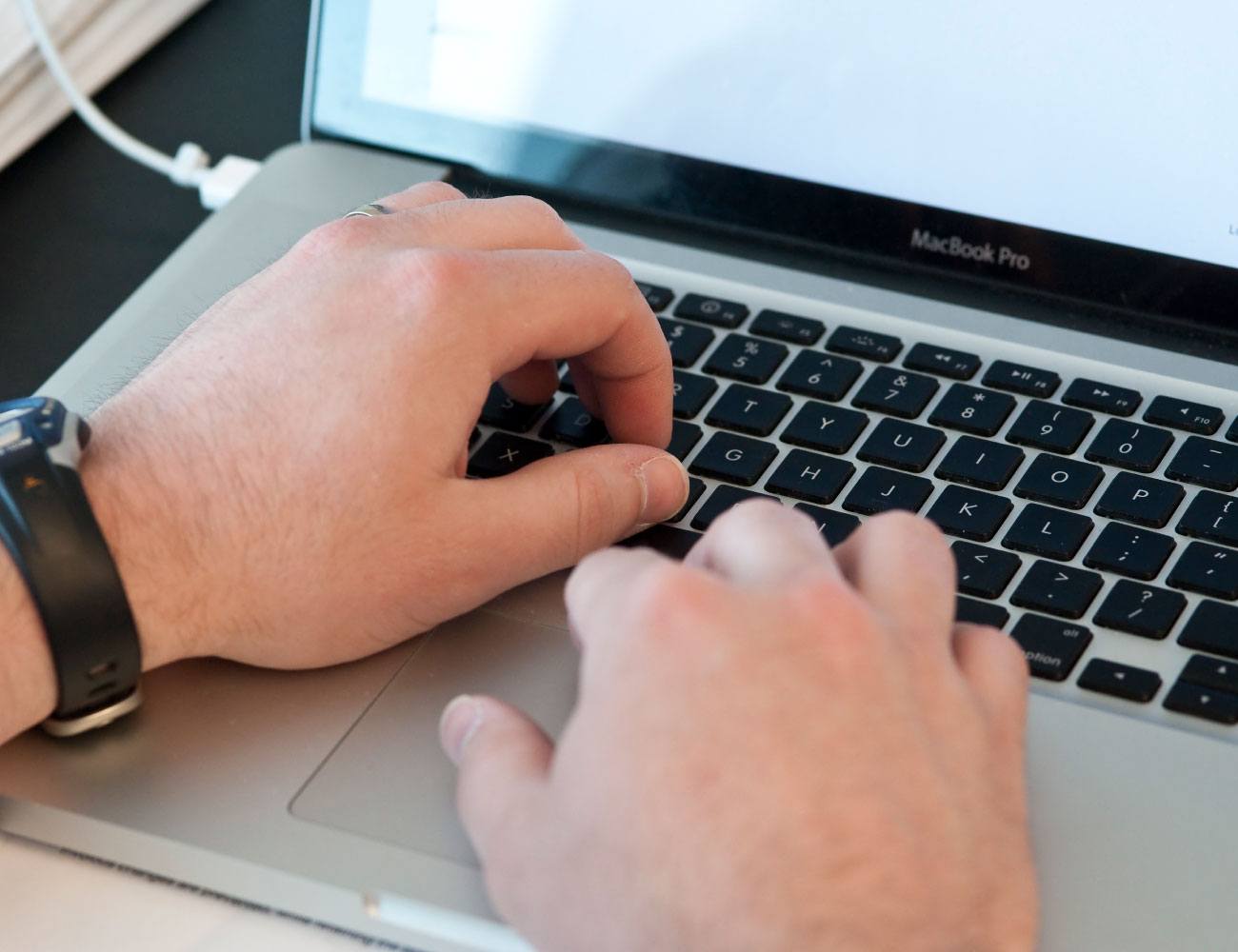close-up of male hands on laptop keyboard